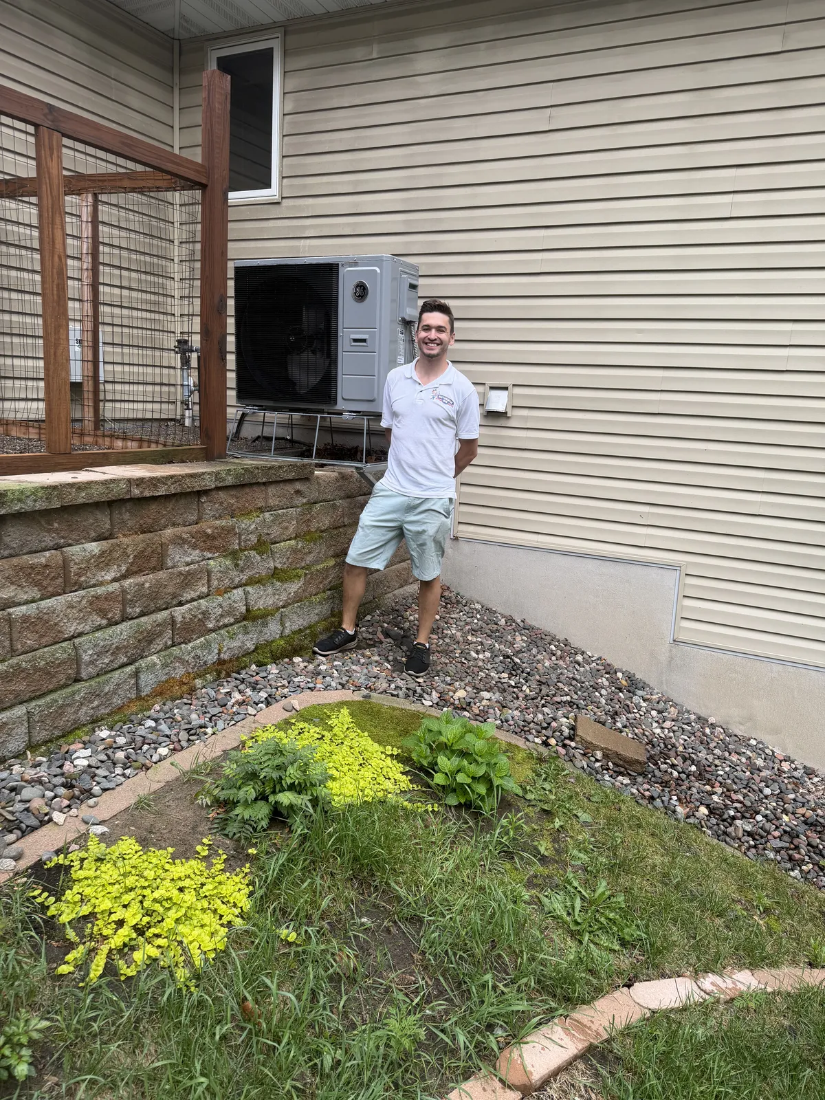 Tim Schultz beside a freshly installed heat pump